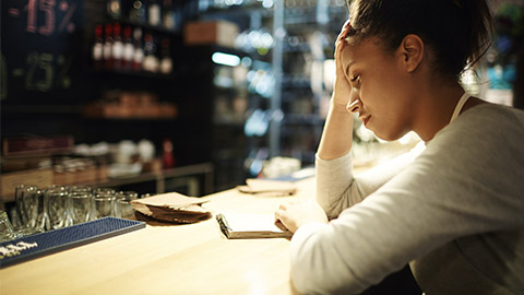 Tired waitress reading notes about orders and tips at the end of working day