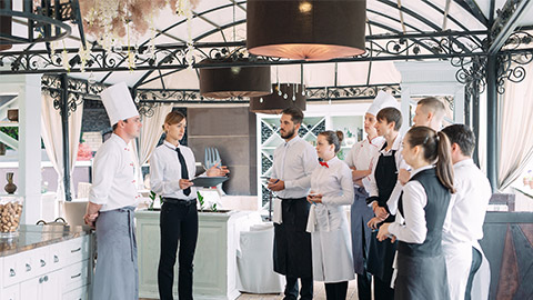 Restaurant manager and his staff in terrace. interacting to head chef in restaurant