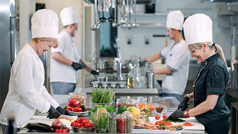 cooks cut vegetables in the restaurant kitchen