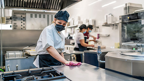 female cook cleaning her kitchen after work