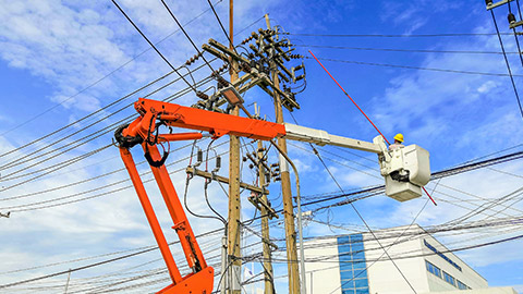 A worker in a cherry picker near a high voltage line