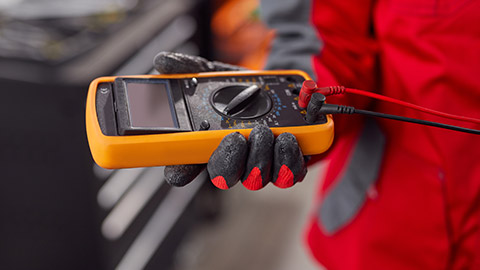 A person holding a multimeter