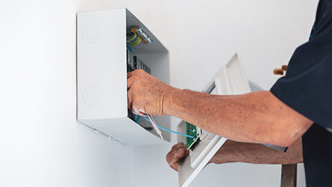 An electrician working on a fuse box