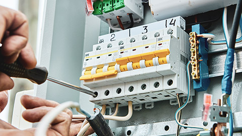 A close view of an electrician working on a fuse box