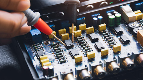 A person testing the circuit with multimeter