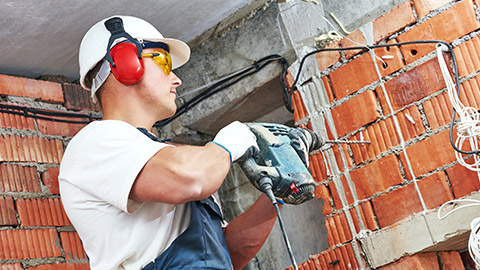 A person using power tools wearing safety gear