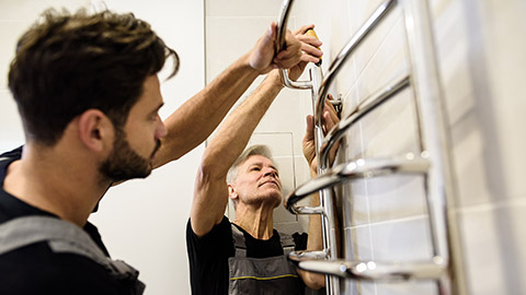 2 electricians installing a heated towel rack