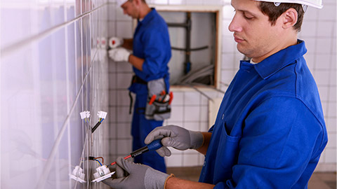 Electricians plumbing a bathroom