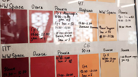 filled with felt-tip pen or black marker hand-written week schedule on wall with color red orange stickers