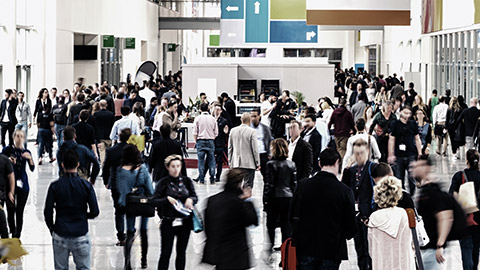 large crowd of anonymous blurred people at a trade fair