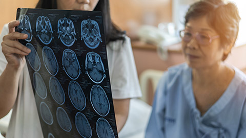 Brain disease diagnosis with medical doctor diagnosing elderly ageing patient