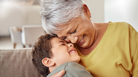 Happy family, child and grandma hug and bond in living room together