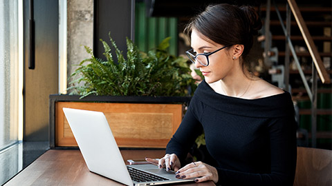 Focused business woman sit on cafe working on laptop