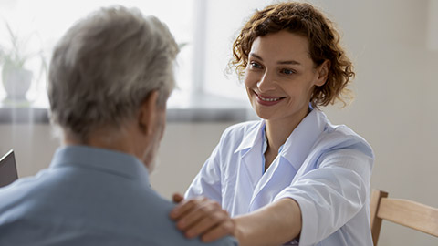 Kind caring young woman nurse or caregiver helping an elder