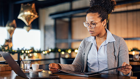 Adult woman with glasses on, enjoying alone at the restaurant.