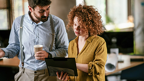 Businesswoman and businessman discussing work in office.