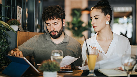 Two businesspeople collaborating in a coffee bar