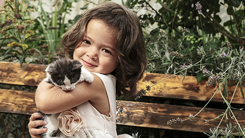 A child holding a kitten