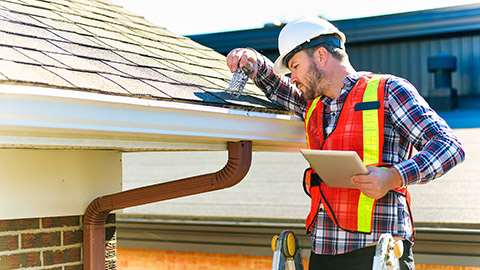 An inspector looking at a house roof