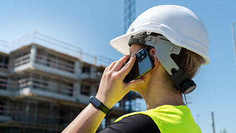 A construction worker talking on a phone