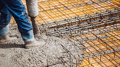 A person pouring concrete on a building site