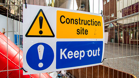 Sign on a construction site fence