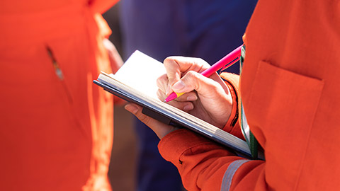 A person writing on a construction site