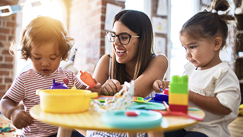 A carer looking over nursery aged children