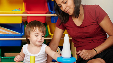 A worker and child interacting with toys