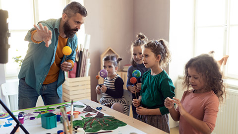 A teacher teaching kids something about the planets