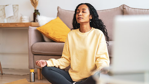 A person meditating in their house