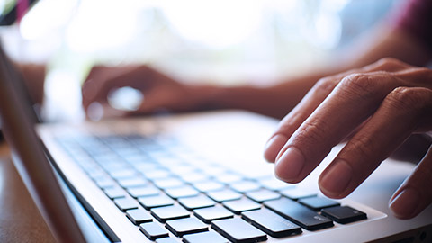 A close view of a person typing on a laptop