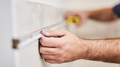 A builder using a tape measure