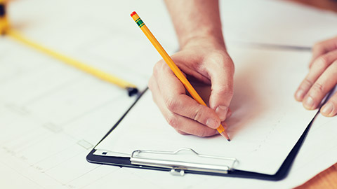 A person writing on a clipboard