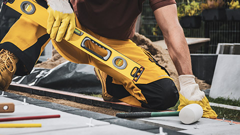 A close view of a person laying pavers