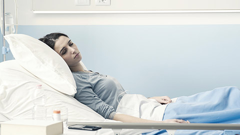 A sick person in a hospital bed