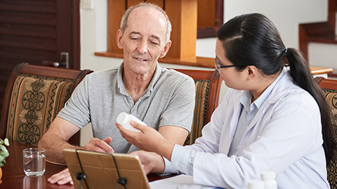 A doctor reading a medication label to a patient