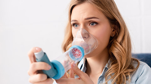 A person using an inhaler