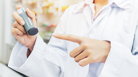 A pharmacist pointing to a ventolin inhaler