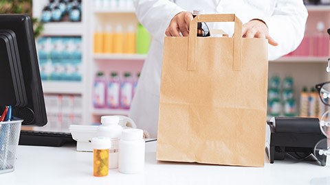 A pharmacist putting medication in a bag