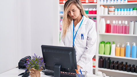 A pharmacist typing on a keyboard