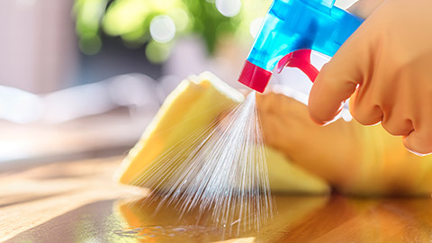 Spraying cleaner onto a surface