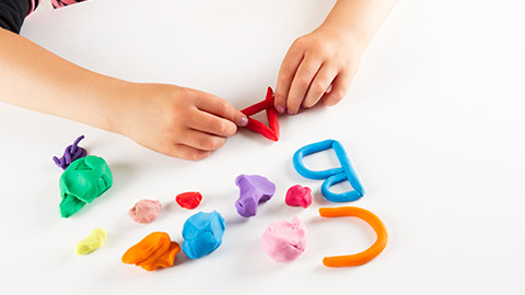 A child making letters out of play dough