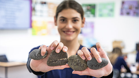 A student holding ricks with writing on them