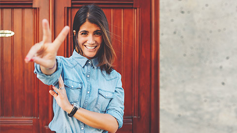 A young person posing infront of the camera holding up two fingers