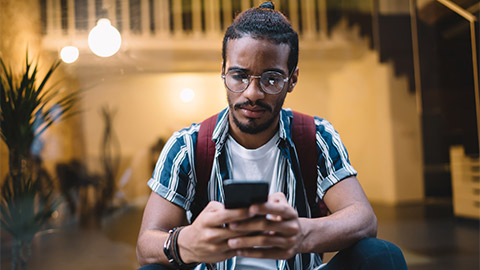 A young person looking concerned while on their phone