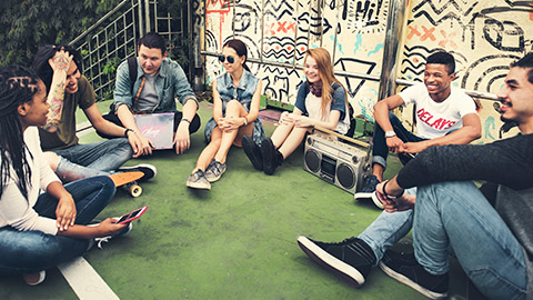 A group of youth with a couple of mentors in a relaxed outdoor environment