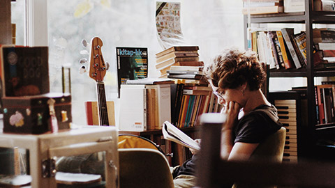 A youth worker reading a book in an indoor space