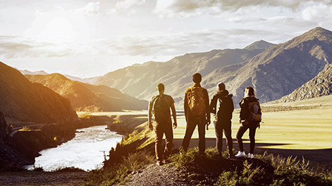 A group of 4 hikers standing in an open space admiring the view