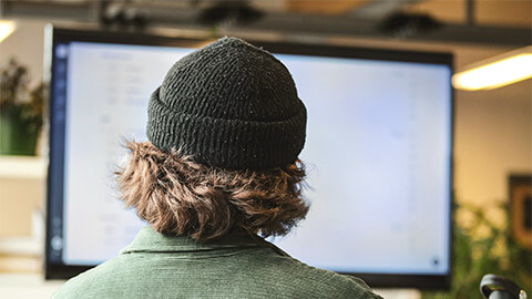 A teenager surfing the web on a large desktop display